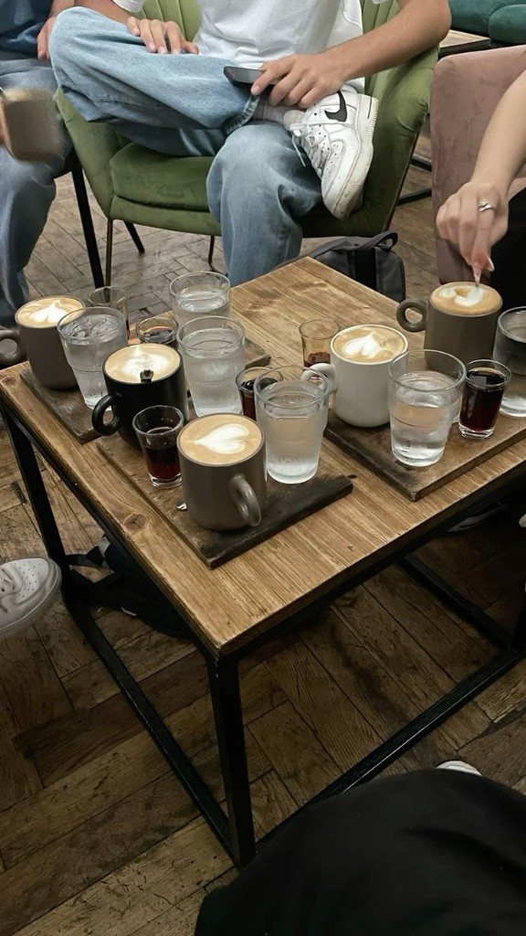 Friends gathered around a table sharing coffee together